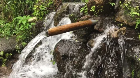 Beautiful waterfall drop from traditional rustic bamboo Stock Footage 146935431