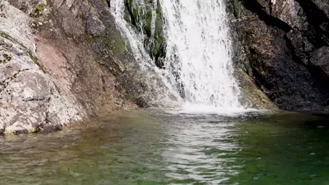 Beautiful waterfall falling into a clear lake  Stock Footage 219487812