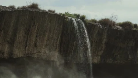 A beautiful waterfall falling in the spring from a rock plate. Cascade Video stock 138158676
