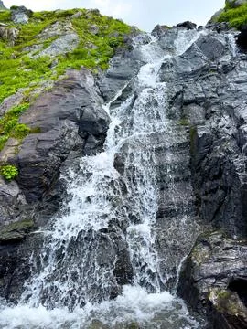 A beautiful waterfall flows down dark rocks Foto stock