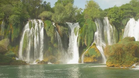 Beautiful waterfall Kravica surrounded by forest flowing into a river, in Bosnia Stock Footage 241597427