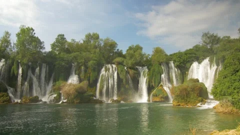 Beautiful waterfall Kravica surrounded by forest flowing into a river, in Bosnia Stock Footage 241696668