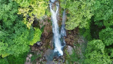 A beautiful waterfall in the middle of a dense forest Stock Footage 167690385