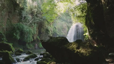 Beautiful waterfall with sun rays in a lush green forest in Oita Vídeos de archivo 336772420