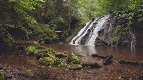 A Beautiful Waterfall Surrounded by Green Tree's and Mossy Rocks Stock Footage 113417890