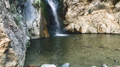 Beautiful waterfall surrounded by rocks Stock Footage 87843350