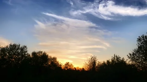 Beautiful wave clouds in blue sky in light of setting sun at golden hour Stock Footage 237606392