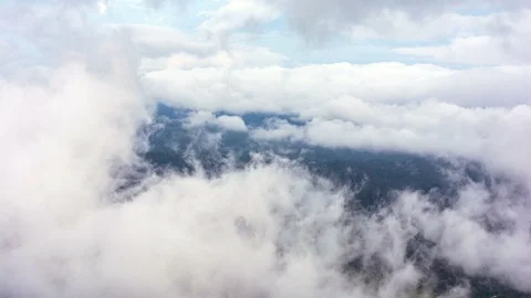 Beautiful waves of low clouds flows in winter mountains - time lapse Stock Footage 99959720