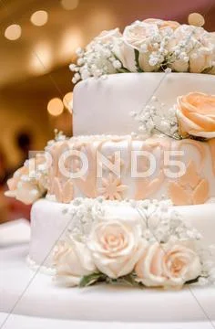 Beautiful wedding cake decorated with orange roses Stock Photos
