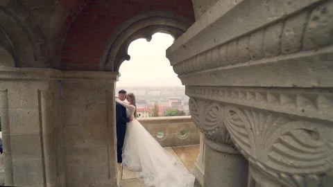 Beautiful wedding couple posing on wall castle near tower Gothic stone architect Stock Footage 129508563