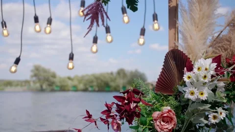 Beautiful wedding decor of flowers. wedding arch decorated with bulbs on the bac Stock Footage 169825527
