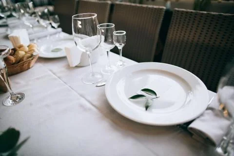 Beautiful wedding table setting. White plates on white tablecloth Stock Photos