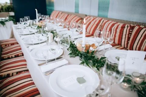 Beautiful wedding table setting. White plates on white tablecloth Stock Photos