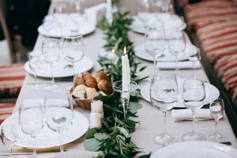 Beautiful wedding table setting. White plates on white tablecloth Stock Photos