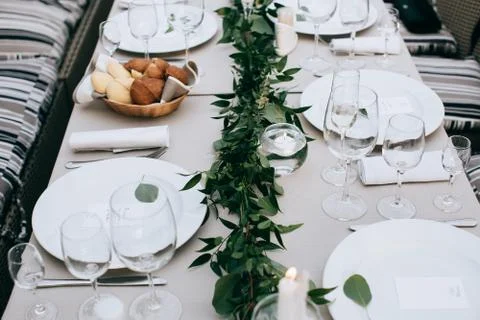 Beautiful wedding table setting. White plates on white tablecloth Stock Photos