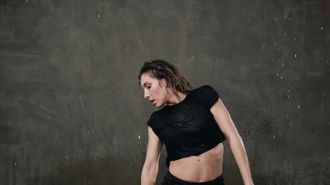 A beautiful wet female dancer performs a dramatic dance under the influence of Stock Footage 89877528
