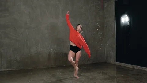 A beautiful wet female dancer performs a dramatic dance under the influence of Stock Footage 90142073