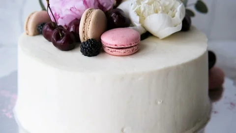 Beautiful white cake decorated with macaroons and flowers Stock Footage 95969960