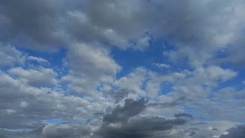 Beautiful white clouds approach the point of view backed by a vivid blue sky Stock Footage 220200625