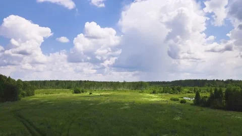 Beautiful white clouds on a blue sky over a green field. Stock Footage 157924419