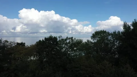 Beautiful white clouds mirroring on the sea with blue sky background Stock Footage 148847839
