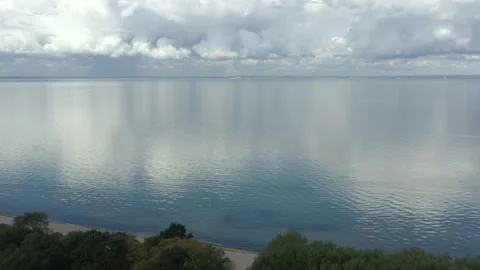 Beautiful white clouds mirroring on the sea with blue sky background Stock Footage 148848129