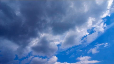 Beautiful white clouds move across the blue sky. Time Laps composition in motion Stock Footage 136774476