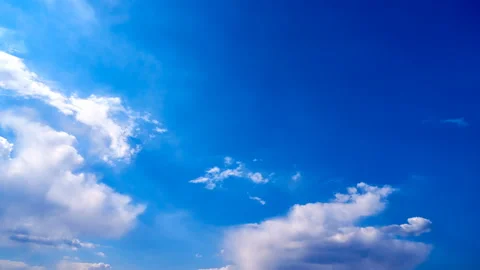 Beautiful white clouds move across the blue sky. Time Laps composition in motion Stock Footage 136776157