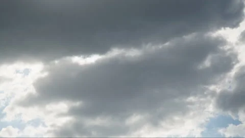 Beautiful white clouds soar across the screen in time lapse fashion over a deep Stock Footage 89581495