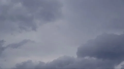 Beautiful white clouds soar across the screen in time lapse fashion over a deep Stock Footage 89711213