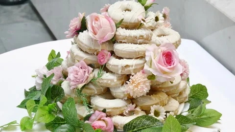 A beautiful white-glazed donut tower centerpiece, elegantly decorated with pink Видео 335936971