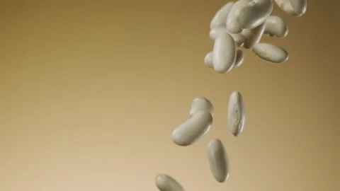 Beautiful white kidney beans falling in slow motion Stock Footage 150979378
