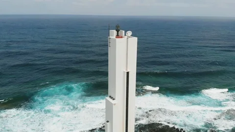 Beautiful white lighthouse on the coast of the Atlantic Ocean, sunny day, aerial Stock Footage 112096695