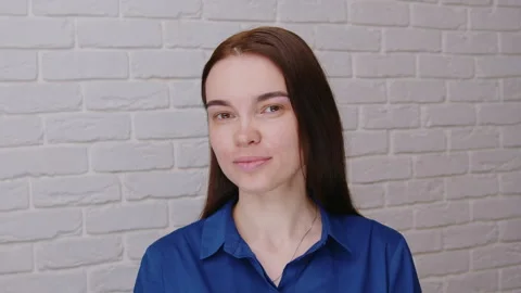 A beautiful white model looks at the camera smiling showing her face from 库存影片 327724032