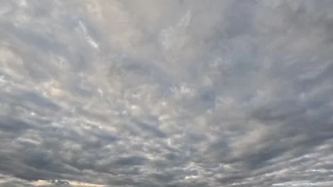 Beautiful white with pink tint clouds moving fast across the sky at dawn Stock Footage 306774594