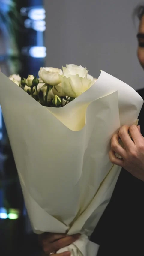 Beautiful white roses in a flower shop. Florist assembles a bouquet to order Stock-Footage 312370341