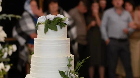  beautiful white wedding cake decorated with a decor of white-green roses Stock Footage 148421237