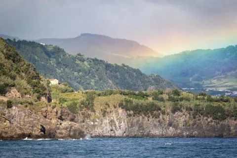 Beautiful wide rainbow over the forests and valley by Ribeira Quente town in  Stock Photos