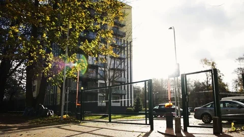 Beautiful wide shot of a automatic gate in front of a building with sun flare Stock Footage 95941572