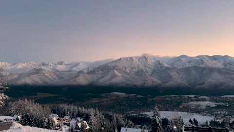 Beautiful wide view of snow-capped mountains in winter at sunset Stock Footage 255555091