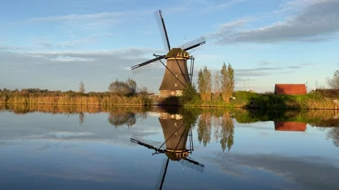 A beautiful windmill with its reflection in the water at kinderdijk in Netherlan Stockbeeldmateriaal 295361474
