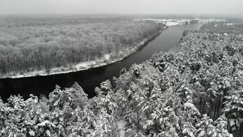 Beautiful winter landscape with a dark river and flakes of wet white snow on the Vídeo Stock 134775952