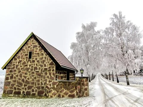 Beautiful winter landscape with empty road small house and snow covered trees Stock Photos