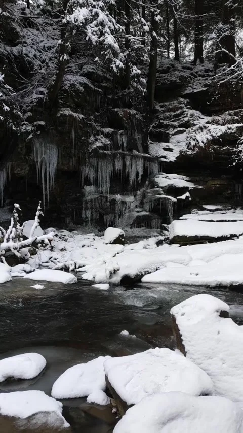 Beautiful winter river flowing between snow-covered rocks Stock Footage 312299271