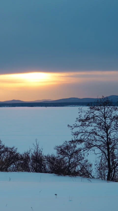 A beautiful winter sunset with a landscape view of the lake and mountains. 스톡 동영상 329637375