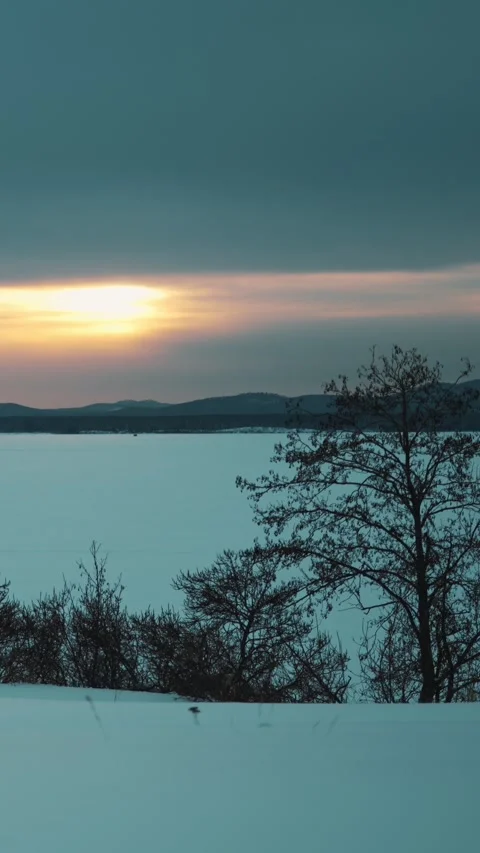 A beautiful winter sunset with a landscape view of the lake and mountains. 스톡 동영상 329637389
