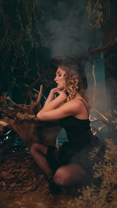 Beautiful witch in pointed hat and black lipstick stands in foggy, mystical Stock-Footage 342068420
