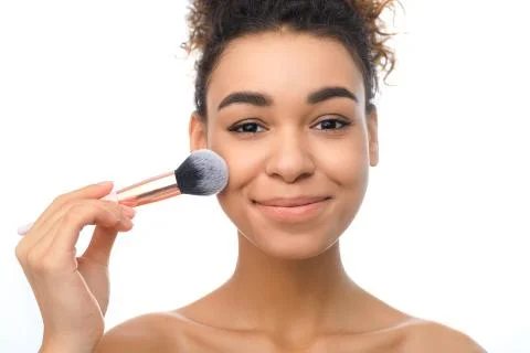 Beautiful woman applying cosmetic powder on her face with tassel Stock Photos