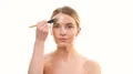The beautiful woman applying the powder on her face on the white background 4k or 4k+ Resolution