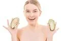 The beautiful woman with an avocado on the white background Photo